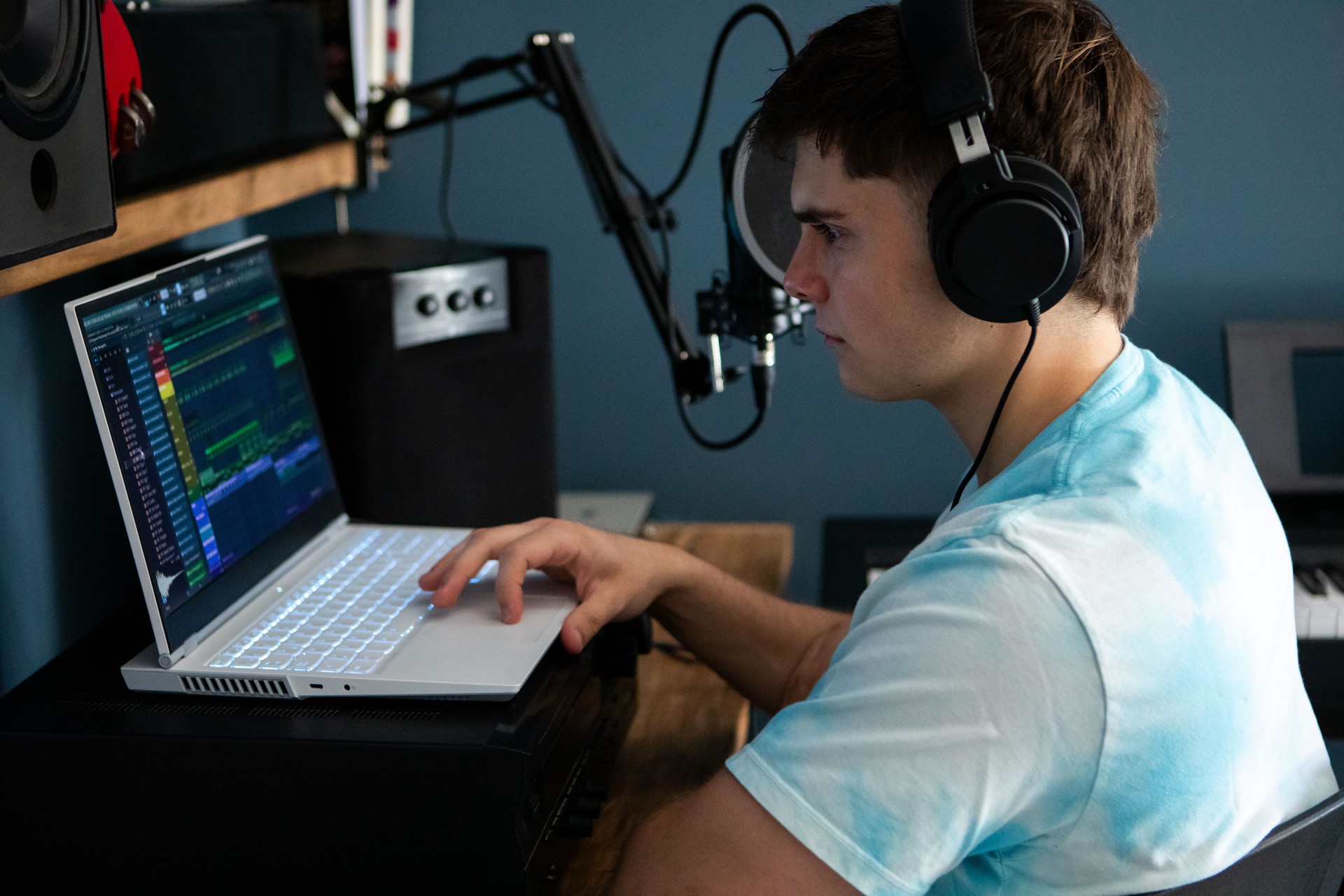 Young man producing music in his home recording music studio